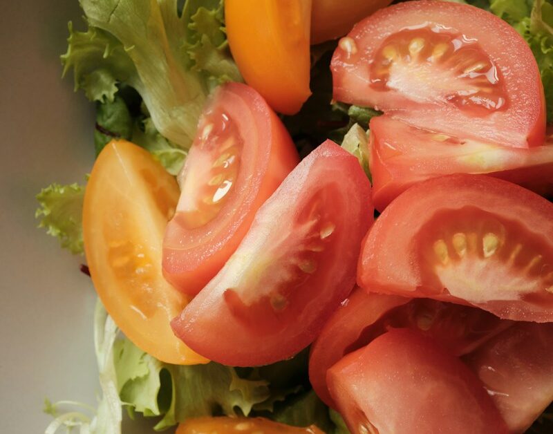 sliced tomato and green vegetable on white ceramic plate